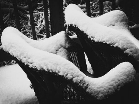 black and white photo of snow on a chair by Inci Jones artist entitled Caress